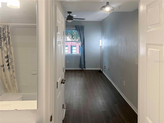 bathroom with ceiling fan, hardwood / wood-style floors, shower / bathtub combination with curtain, and a textured ceiling