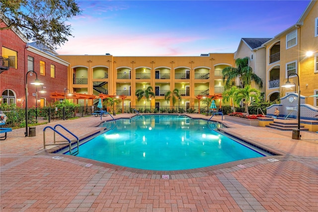 pool at dusk with a patio