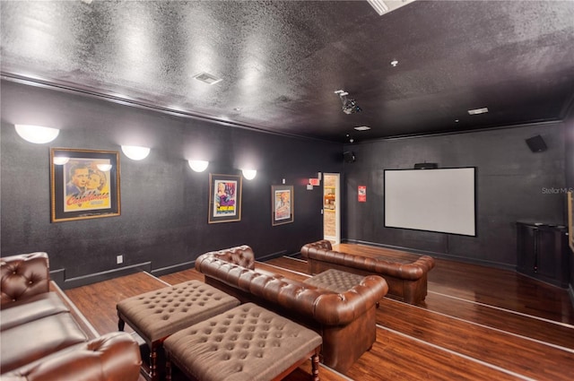 cinema room featuring dark hardwood / wood-style flooring and a textured ceiling