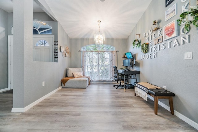 office space with light hardwood / wood-style floors, vaulted ceiling, and a notable chandelier