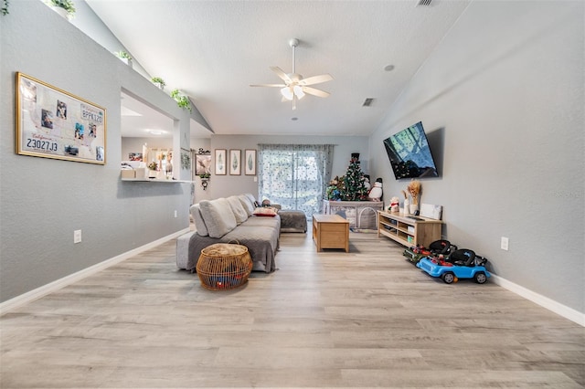 living area featuring ceiling fan, light hardwood / wood-style floors, and lofted ceiling