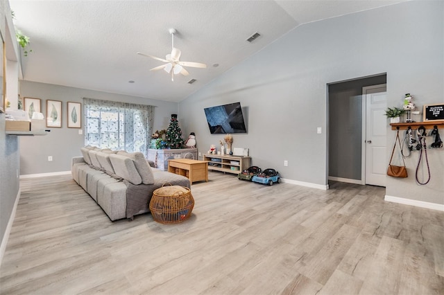 living room featuring a textured ceiling, light hardwood / wood-style flooring, vaulted ceiling, and ceiling fan