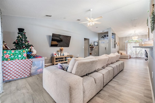 living room featuring light hardwood / wood-style flooring, vaulted ceiling, and ceiling fan