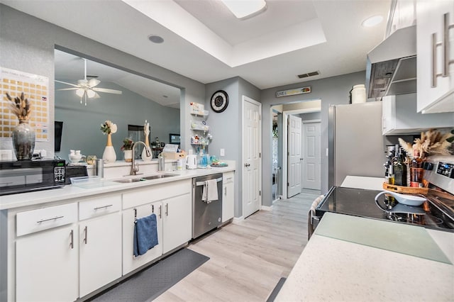 kitchen featuring sink, appliances with stainless steel finishes, extractor fan, white cabinets, and light wood-type flooring