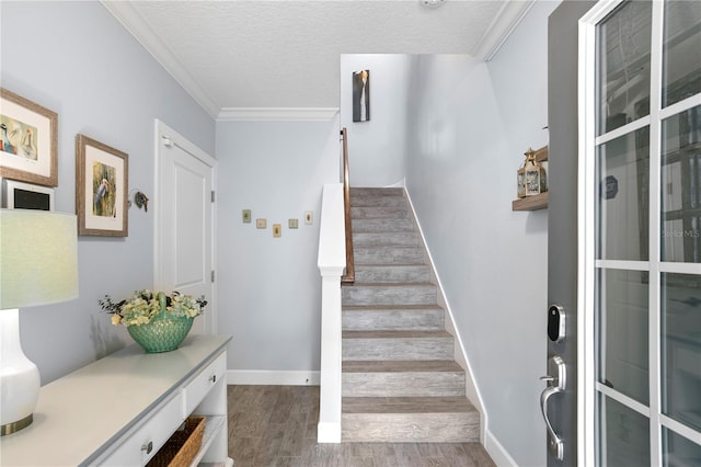 stairway featuring crown molding, wood-type flooring, and a textured ceiling