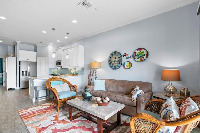 living room featuring light hardwood / wood-style floors and crown molding