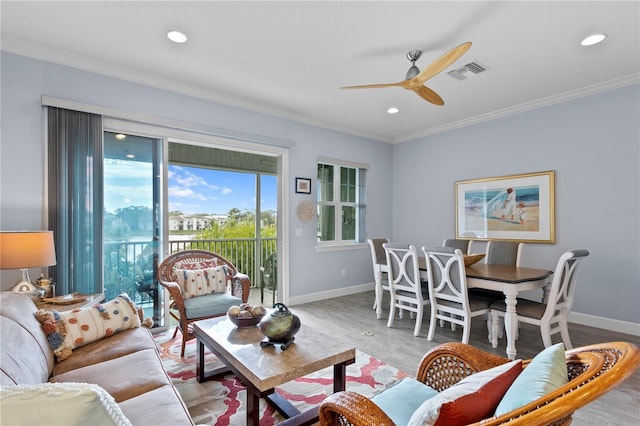 living room with hardwood / wood-style floors, ceiling fan, and ornamental molding