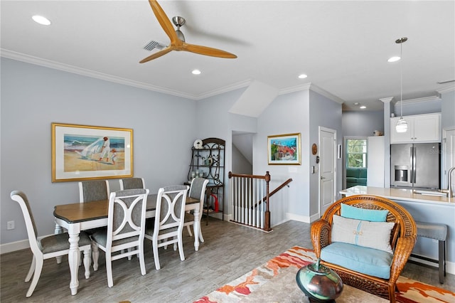 dining area featuring ceiling fan, light hardwood / wood-style flooring, sink, and ornamental molding