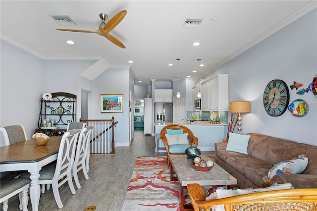 living room with ceiling fan, light hardwood / wood-style floors, and ornamental molding