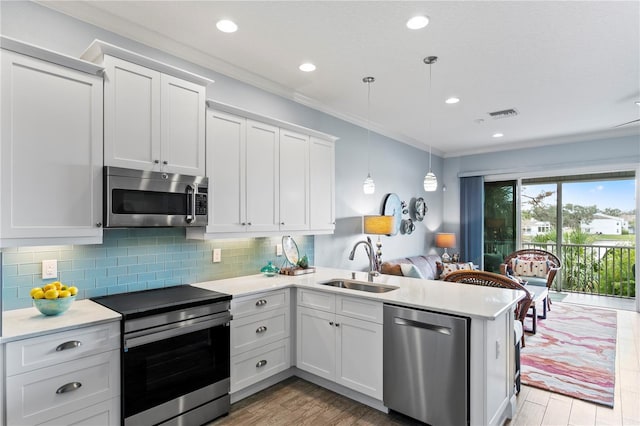 kitchen featuring white cabinetry, sink, pendant lighting, and appliances with stainless steel finishes