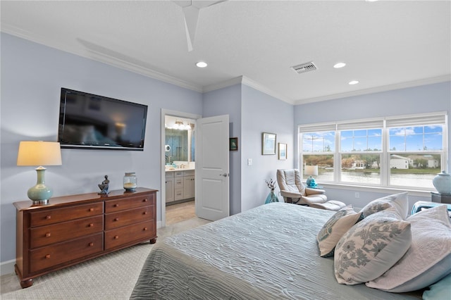 carpeted bedroom with ensuite bathroom, ceiling fan, and crown molding