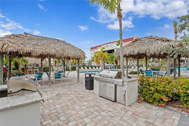 view of patio / terrace with area for grilling, exterior kitchen, and a community pool