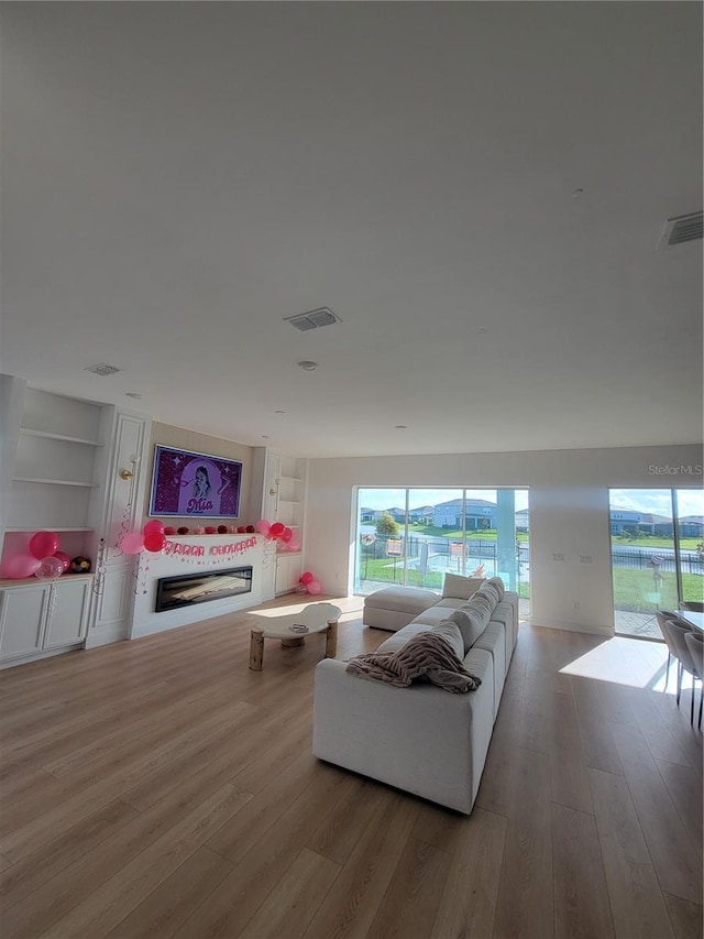 living room with light hardwood / wood-style floors and built in features