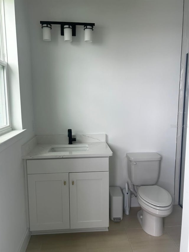 bathroom with tile patterned flooring, vanity, and toilet