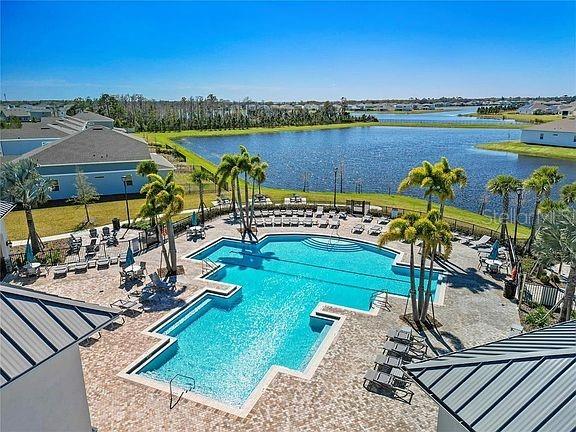 view of swimming pool featuring a patio and a water view