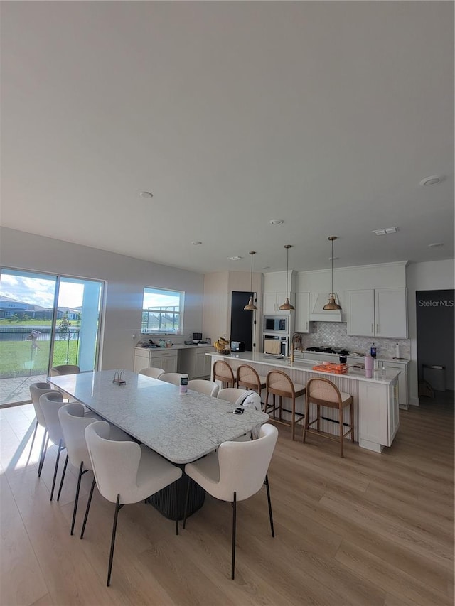 dining area featuring light wood-type flooring and visible vents