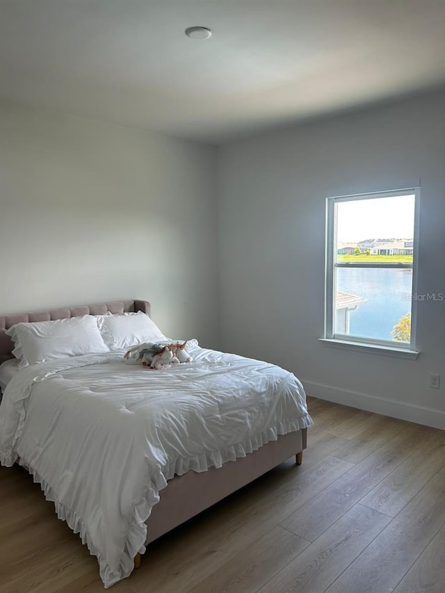 bedroom with wood finished floors and baseboards