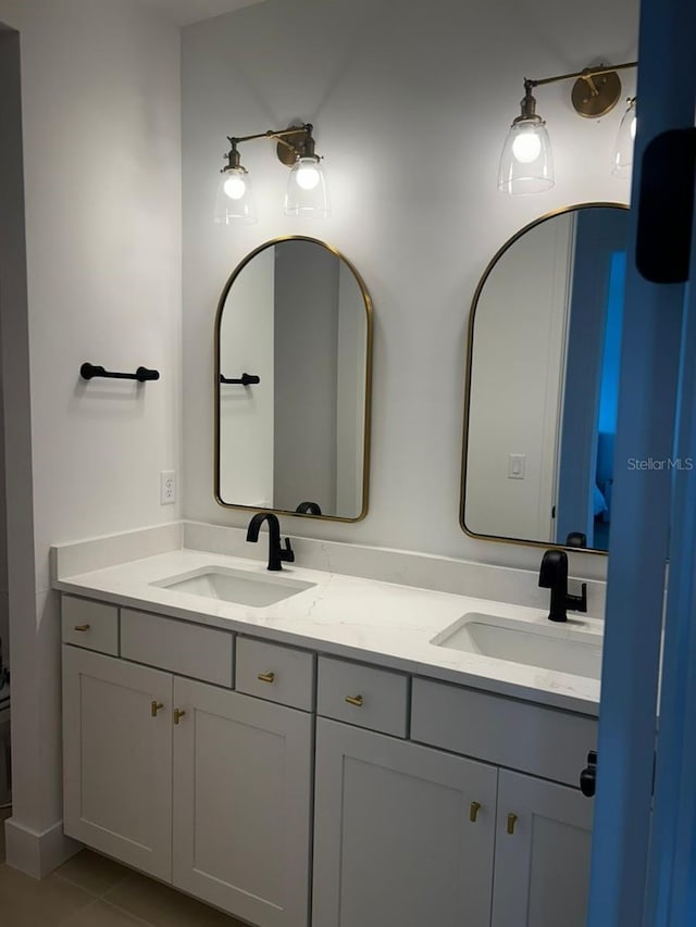 bathroom featuring tile patterned flooring, a sink, and double vanity