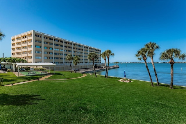 view of property's community with a lawn and a water view