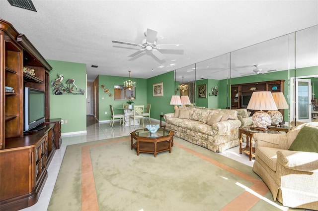 tiled living room featuring visible vents, a textured ceiling, baseboards, and ceiling fan with notable chandelier