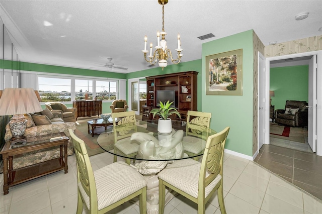 dining room featuring light tile patterned floors, visible vents, a textured ceiling, baseboards, and ceiling fan with notable chandelier