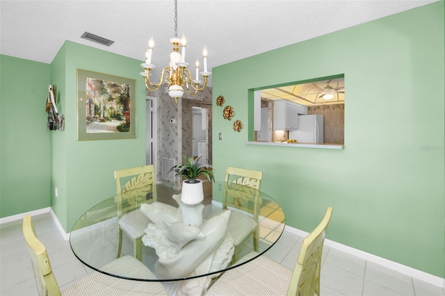 dining space featuring light tile patterned floors, an inviting chandelier, visible vents, and baseboards