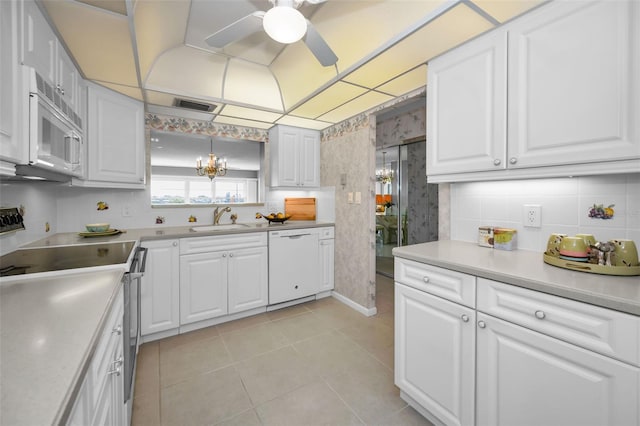 kitchen featuring hanging light fixtures, white appliances, and white cabinets