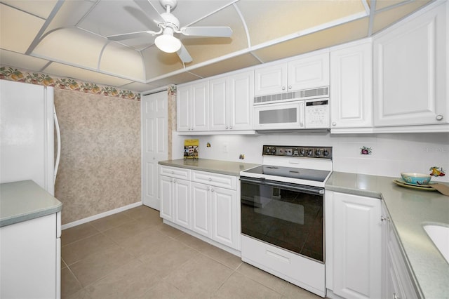 kitchen with light countertops, a ceiling fan, white cabinetry, light tile patterned flooring, and white appliances