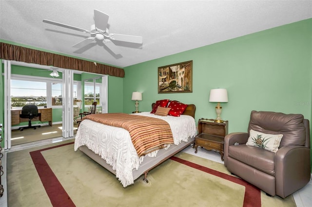 bedroom featuring access to exterior, ceiling fan, and a textured ceiling