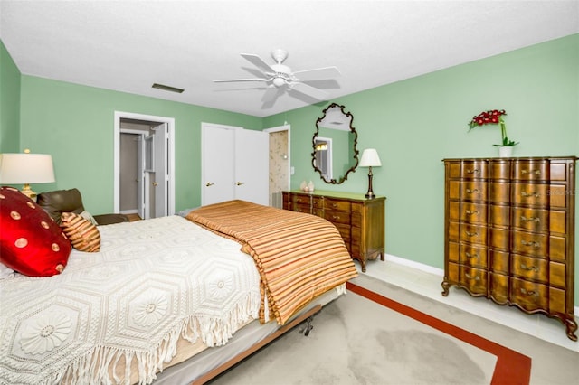 carpeted bedroom with a ceiling fan, visible vents, and baseboards