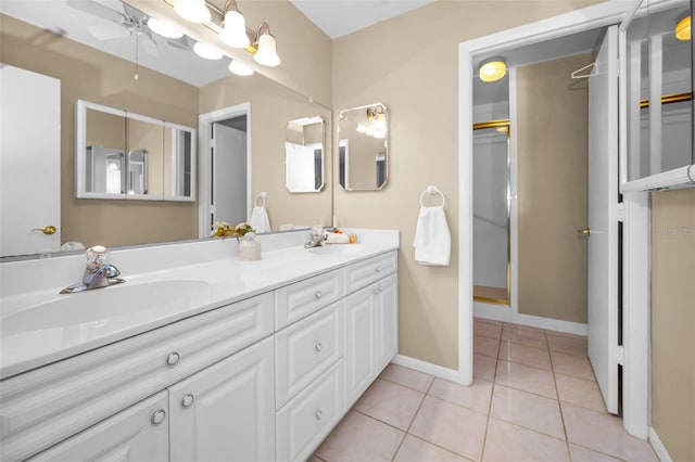 bathroom featuring tile patterned flooring, a sink, baseboards, and double vanity