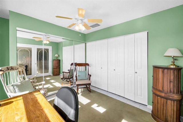 home office with light tile patterned floors, visible vents, and a ceiling fan