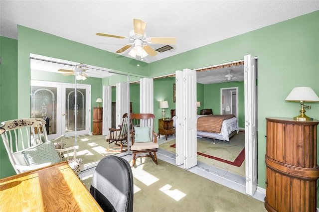 interior space featuring visible vents, light colored carpet, ceiling fan, and a textured ceiling