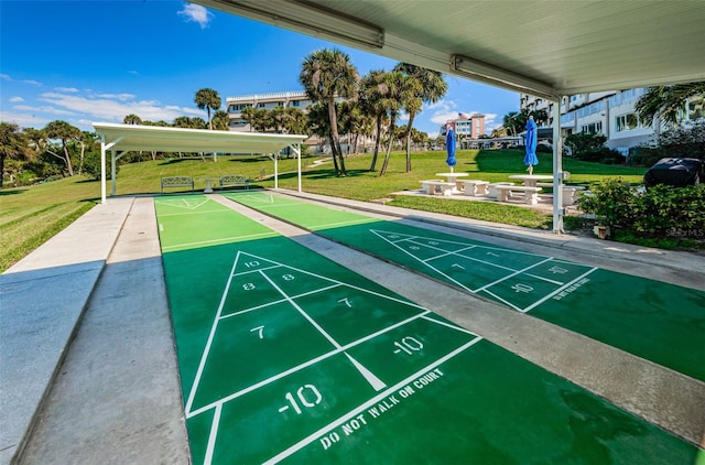 view of community featuring shuffleboard and a lawn