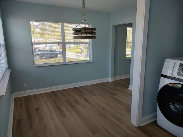 unfurnished dining area with plenty of natural light, dark wood-type flooring, and washer / dryer