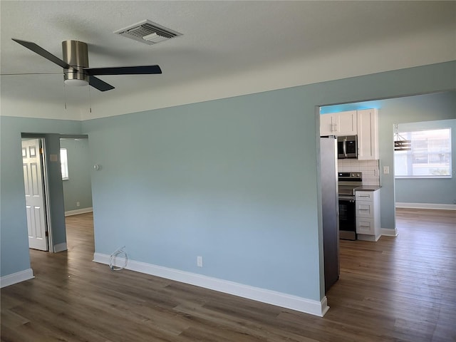 unfurnished room featuring dark hardwood / wood-style floors and ceiling fan