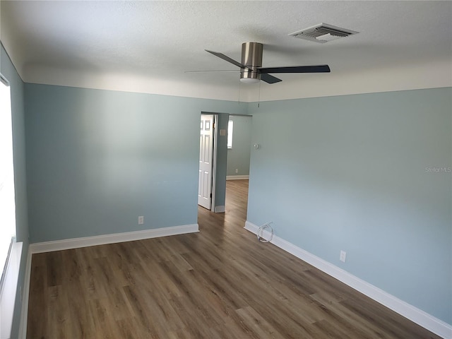 empty room featuring ceiling fan and dark wood-type flooring