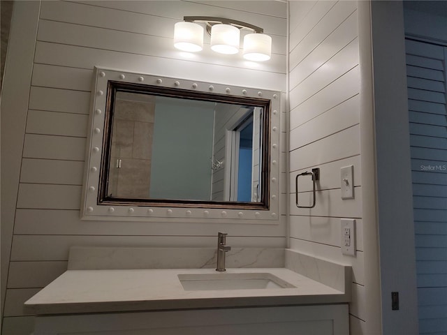 bathroom with vanity and wooden walls