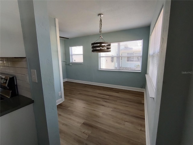 unfurnished dining area featuring dark hardwood / wood-style flooring and a notable chandelier