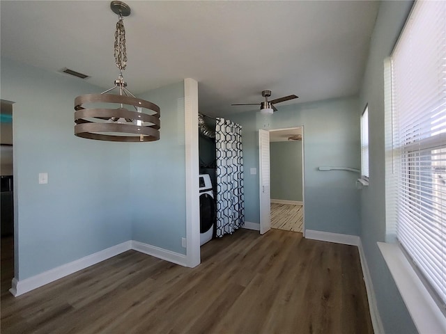 unfurnished dining area featuring washer / clothes dryer, ceiling fan, and dark hardwood / wood-style flooring