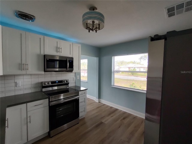 kitchen featuring light hardwood / wood-style floors, white cabinetry, stainless steel appliances, and tasteful backsplash