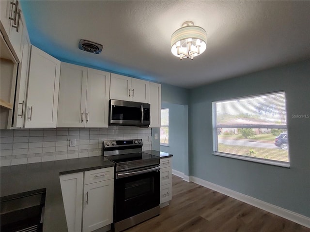 kitchen with decorative backsplash, stainless steel appliances, white cabinetry, and dark hardwood / wood-style floors