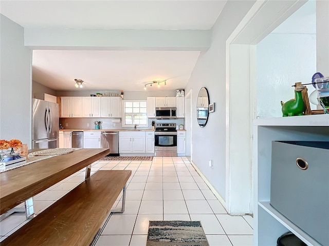 kitchen featuring white cabinets, light tile patterned floors, stainless steel appliances, and sink