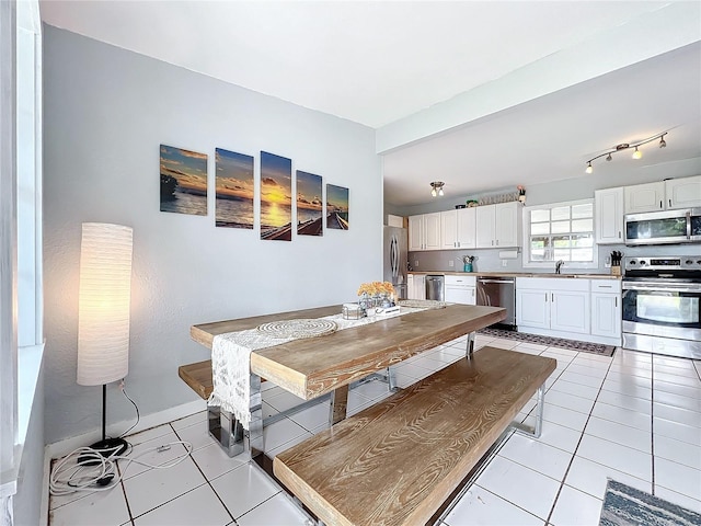 dining area featuring sink and light tile patterned floors