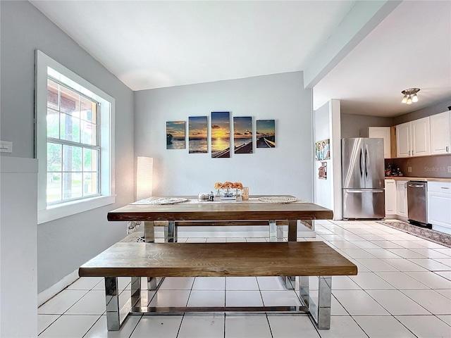 dining room featuring light tile patterned floors and vaulted ceiling