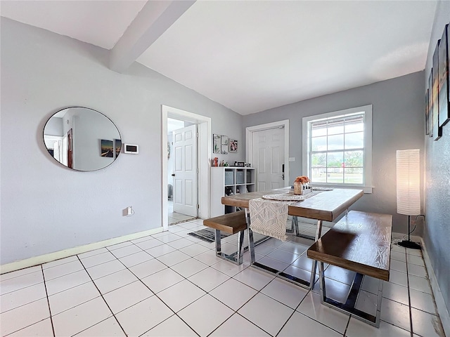 dining area featuring vaulted ceiling with beams and light tile patterned floors