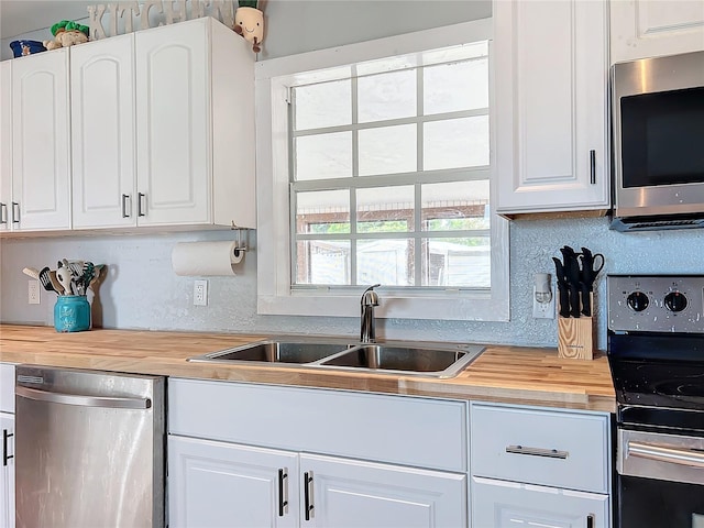 kitchen featuring butcher block countertops, sink, white cabinets, and stainless steel appliances