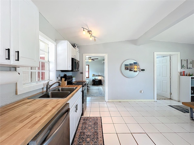 kitchen featuring light tile patterned flooring, lofted ceiling, sink, and appliances with stainless steel finishes