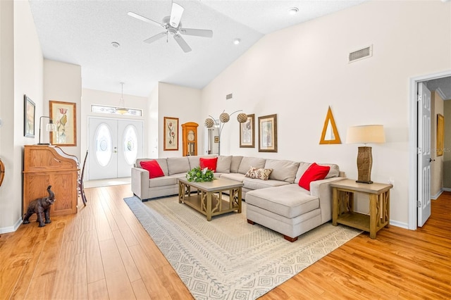 living room featuring a textured ceiling, hardwood / wood-style flooring, high vaulted ceiling, and ceiling fan