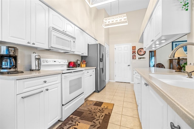 kitchen with pendant lighting, white appliances, white cabinets, sink, and light tile patterned floors